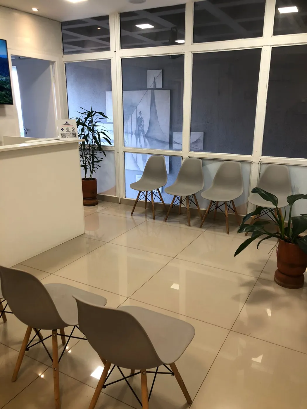 Sala de espera da Conic Odontologia, com janelas amplas e cadeiras claras