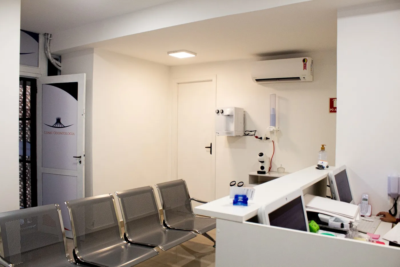 Sala de espera com a logo da Conic na porta